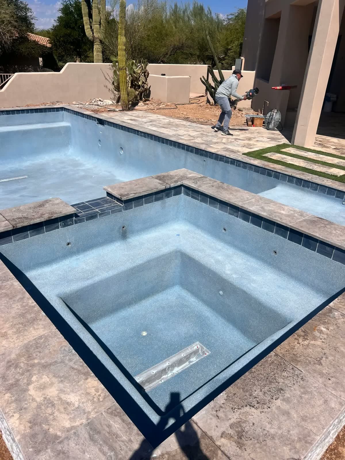 Empty pool and square spa with a fresh blue finish and dark blue tile