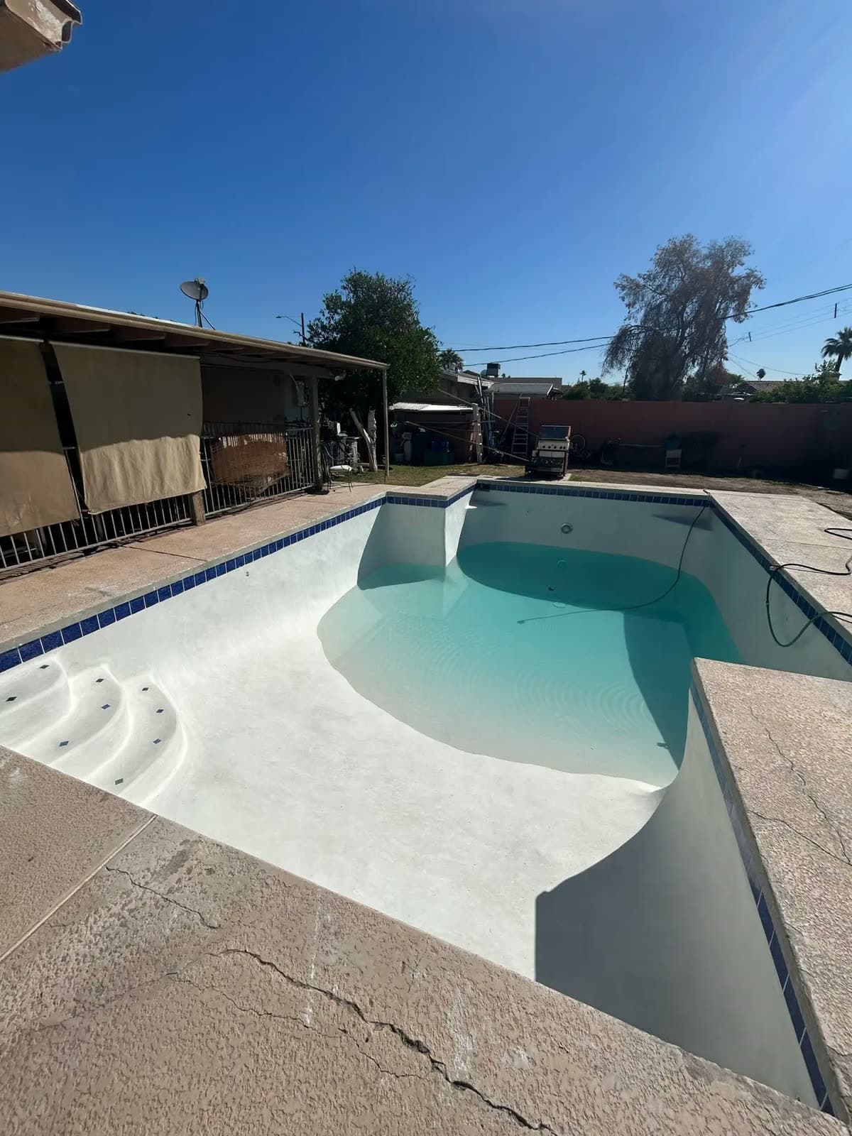 New white plaster pool starting to fill with water