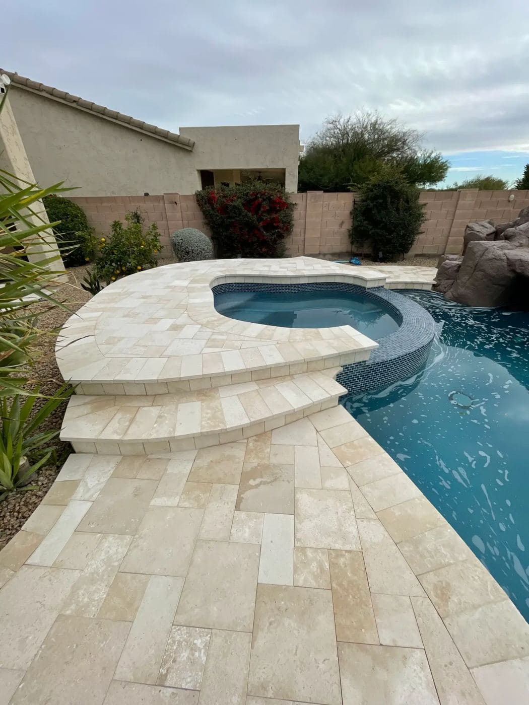Stone coping and paving around a curved spa